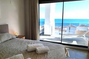 ein Schlafzimmer mit Bett und Blick auf das Meer in der Unterkunft Blue Suites in Manilva + 58 Fotos