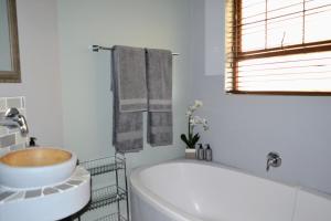 a white bathroom with a tub and a sink at Cherry Grove 2 in Dullstroom