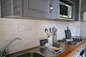 a kitchen counter with a sink and a microwave at Cherry Grove 2 in Dullstroom
