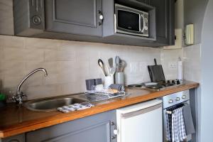 a kitchen counter with a sink and a microwave at Cherry Grove 2 in Dullstroom +18 photos