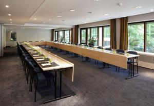 ブリュッセルにあるNH ブリュッセル グランプラス アレンベルグの大きな会議室(長いテーブルと椅子付)