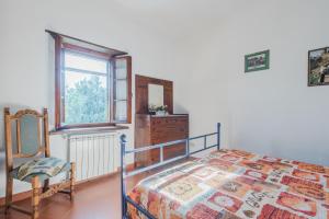 a bedroom with a bed and a window and a dresser at Chiantishire Lovely Cottage with Garden & Parking! in Castelnuovo Berardenga