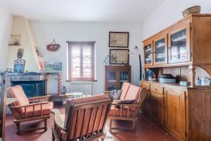 ein Wohnzimmer mit Stühlen und einem Tisch und einem Kamin in der Unterkunft CHIANTI - Lovely Cottage with Parking & Garden! in Castelnuovo Berardenga