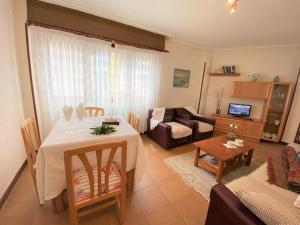 una sala de estar con una mesa y un sofá en Apartamentos Playa del Sable, en Isla