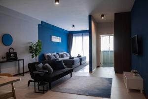 - un salon avec un canapé et un mur bleu dans l'établissement Deluxe Seaview Suite Twin Bed by The Only Bnb, à Tanjong Tokong