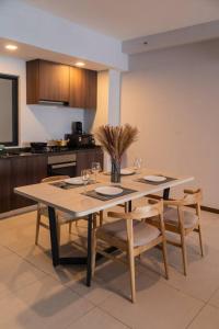 einen Esstisch mit Stühlen und eine Küche in der Unterkunft Deluxe Seaview Suite Twin Bed by The Only Bnb in Tanjong Tokong