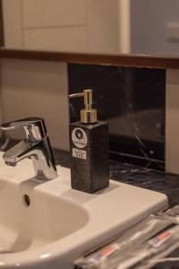a bottle of soap sitting on top of a sink at Deluxe Seaview Suite Twin Bed by The Only Bnb in Tanjong Tokong