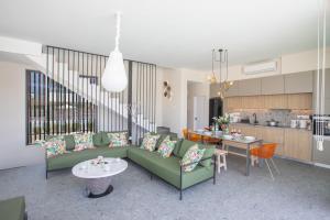 uma sala de estar com um sofá verde e uma cozinha em Protaras Elite Pearl Villa Ep17 em Protaras