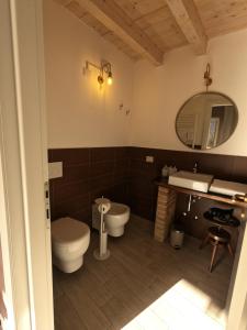 a bathroom with a toilet and a sink and a mirror at B&B Il Pozzo e la Macina in Bardi