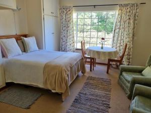 ヒメヴィルにあるYellowwood Cottageのベッドルーム1室(ベッド1台、テーブル、窓付)