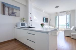 a white kitchen with a sink and a microwave at SEA FRONT - Panoramic view with Terraсe - 2BR in Nice