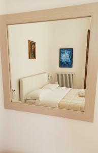 a mirror reflecting a bed in a bedroom at Casa Lilly in Porto SantʼElpidio