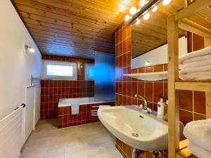 łazienka z białą umywalką i czerwonymi kafelkami w obiekcie Chalet Augustine Hinterglemm Zentrum w Saalbach Hinterglemm +30 zdjęć