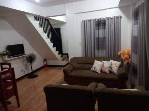 a living room with a couch and a staircase at Nellie's Place in Puerto Princesa City