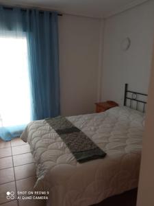 a bedroom with a large bed with a window at Apartamento PUERTO REY 2 in Vera