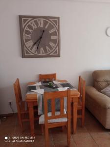 a table and chairs with a clock on the wall at Apartamento PUERTO REY 2 in Vera