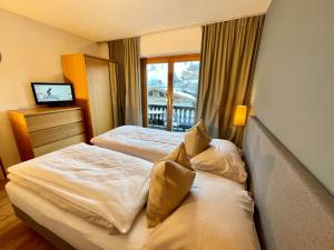 pokój hotelowy z dwoma łóżkami i oknem w obiekcie Chalet Augustine Hinterglemm Zentrum w Saalbach Hinterglemm