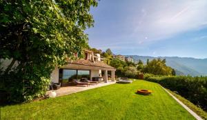 ein Haus mit einem großen Garten mit grünem Gras in der Unterkunft Sunset House with gorgeous view of the lake in Montreux