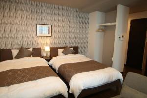 two beds in a hotel room with at SA Inn Ina Nice Road - Vacation STAY 87470v in Ina