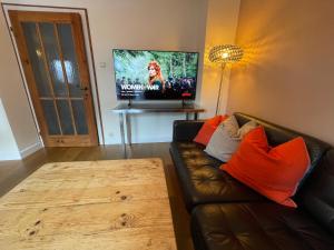 salon z kanapą i telewizorem z płaskim ekranem w obiekcie Chalet Augustine Hinterglemm Zentrum w Saalbach Hinterglemm