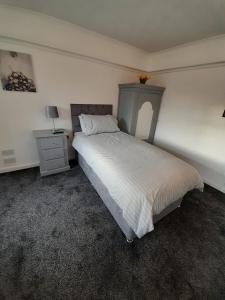 a bedroom with a large bed and a nightstand and a bed sidx sidx sidx at riverside rooms at wheelgate house in Goole