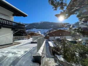 pokryty śniegiem chodnik do domu z widokiem na góry w obiekcie Chalet Augustine Hinterglemm Zentrum w Saalbach Hinterglemm
