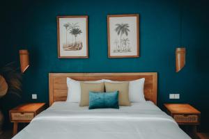 PORTER HOTEL - Surf & Yoga Retreat في كوتا لومبوك: غرفة نوم بسرير كبير بجدران زرقاء