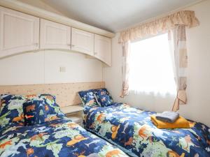 a bedroom with two beds and a window at Mountain View Lodge 2 in Holyhead