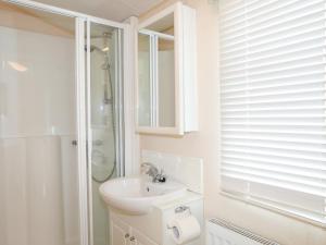 a white bathroom with a sink and a shower at Mountain View Lodge 2 in Holyhead +26 photos