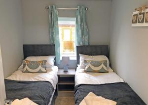 two twin beds in a room with a window at Ribble Valley View in Langho