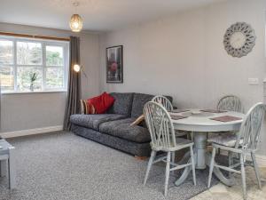 sala de estar con sofá, mesa y sillas en Beech Cottage - Uk42883, en Benllech