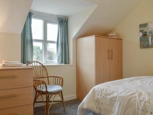 1 dormitorio con 1 cama, vestidor y ventana en Beech Cottage - Uk42883, en Benllech