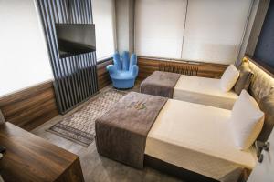 a room with two beds and a flat screen tv at Rhisos Gold Otel in Rize