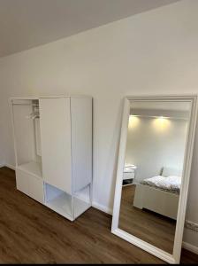 a mirror in a room with a bed and a bedroom at Schöne Wohnung nahe Köln in Cologne