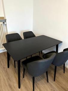 uma mesa de jantar preta e cadeiras num quarto em Schöne Wohnung nahe Köln em Colônia