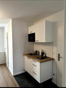 uma cozinha com armários brancos e um lavatório em Schöne Wohnung nahe Köln em Colônia