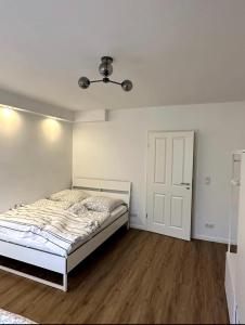 a white bedroom with a bed and a ceiling at Schöne Wohnung nahe Köln in Cologne