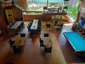 un restaurante vacío con mesas y una mesa de billar en MB's Garden Inn en Isla de Mactán