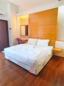 a bedroom with a large bed with a wooden headboard at Heritage 12 Homestay Studio 4Pax Free WIFI Netflix in Seri Kembangan