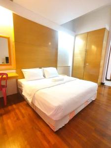 a bedroom with a large white bed and a wooden floor at Heritage 12 Homestay Studio 4Pax Free WIFI Netflix in Seri Kembangan