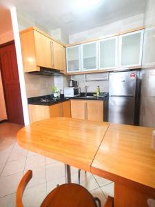 a kitchen with a wooden table and a stainless steel refrigerator at Heritage 12 Homestay Studio 4Pax Free WIFI Netflix in Seri Kembangan