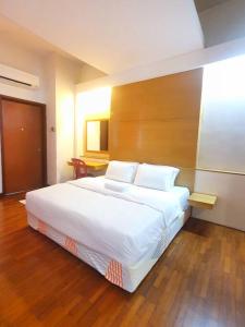 a bedroom with a large white bed in a room at Heritage 12 Homestay Studio 4Pax Free WIFI Netflix in Seri Kembangan