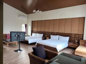 ein Hotelzimmer mit 2 Betten und einem TV in der Unterkunft 艸祭莊園 in Pi-tzu-t'ou