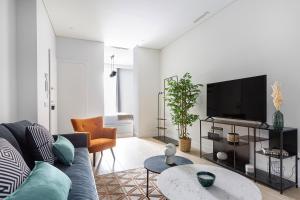 uma sala de estar com um sofá e uma televisão de ecrã plano em Palafox Design - Darya Living em Madrid