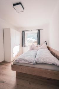 - une chambre avec un grand lit et une fenêtre dans l'établissement Appartement Reichholf, à Bramberg am Wildkogel