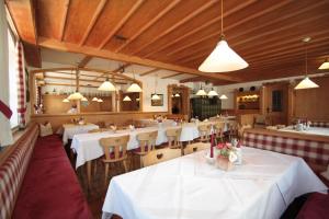 un ristorante con tavoli e sedie bianchi e luci di Ferienwohnungen Kirschner a Bad Birnbach