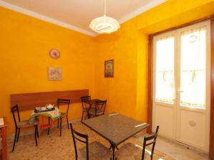 a dining room with yellow walls and a table and chairs at Piccadilly House in Catania