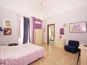 1 dormitorio con 1 cama y 1 silla azul en Piccadilly House, en Catania