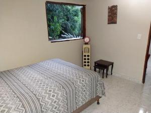1 dormitorio con cama y ventana con acuario en Linda Casa de Campo Sitio Chácara em Campinas, en Campinas