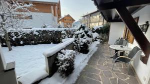 a snow covered yard with a table and a fence at Ferienwohnung Pauliner in Oberstdorf